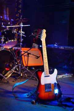 Electric guitar and other musical equipment on stage before conc