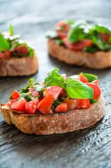 Italian bruschetta with chopped vegetables, herbs and oil on gr