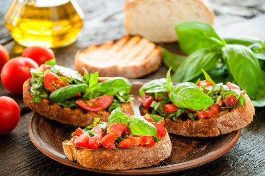 Italian bruschetta with chopped vegetables, herbs and oil on gr