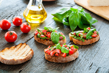 Italian bruschetta with chopped vegetables, herbs and oil on gr