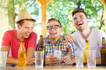 Friends drinking and using smartphone