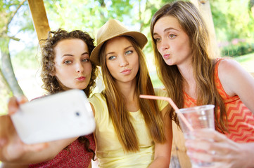 Girls taking selfie with smartphone in pub