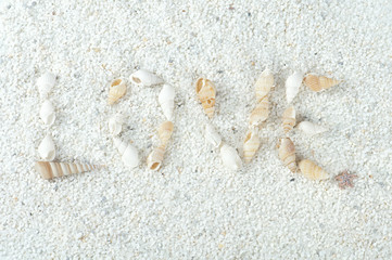 the inscription love, made of shells on the sand