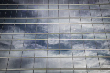 contemporary, skyscraper with glass facade and clouds reflected
