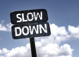 Slow Down sign with clouds and sky background