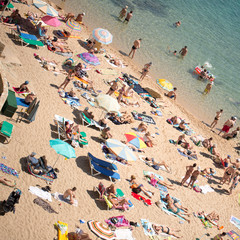 Fototapeta na wymiar People and sun umbrellas on the beach