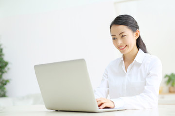ノートパソコンを使う若い女性