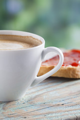 Coffee cup on a wooden table outdoors