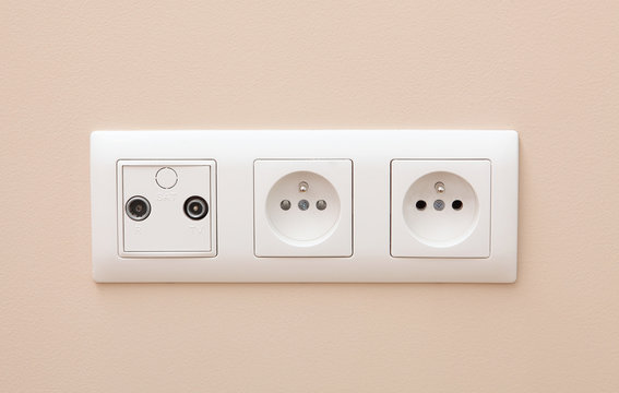 White electric socket on the wall.