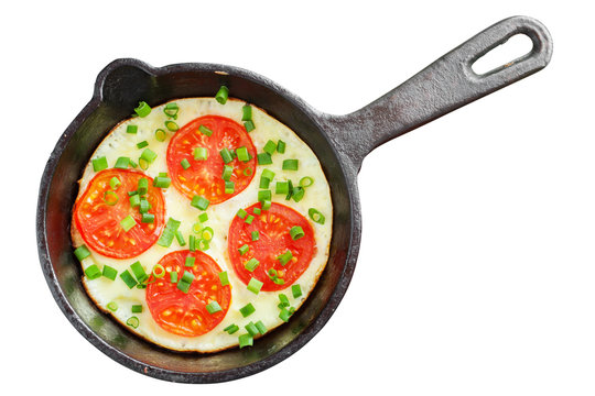 frying pan with scrambled eggs and tomatoes