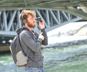 bearded young man with backpack headphone and binocular