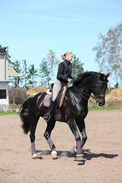 Young woman riding black horse