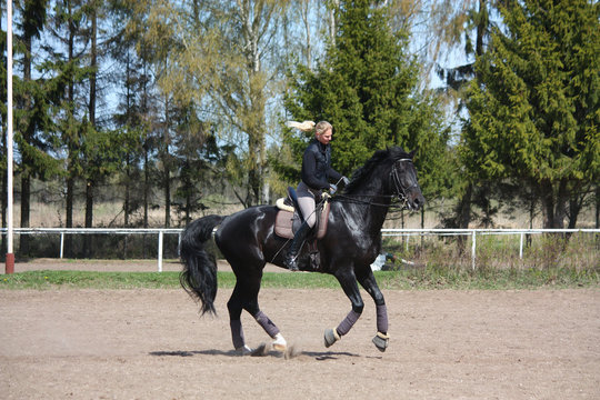 Young woman riding black horse