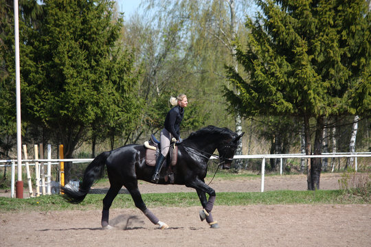 Young woman riding black horse