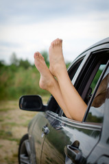 Woman's legs out of the car window.