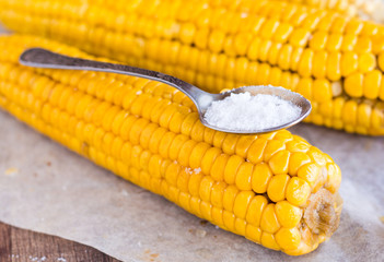 boiled yellow corn and a teaspoon of salt, close up