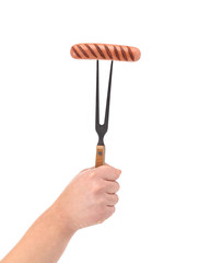 Hand holding fork with grilled sausage.
