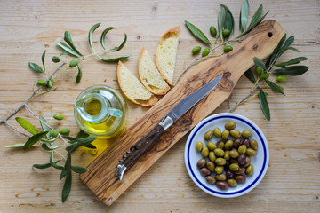 Oliven und Ölivenöl arrangiert auf einem Holztisch