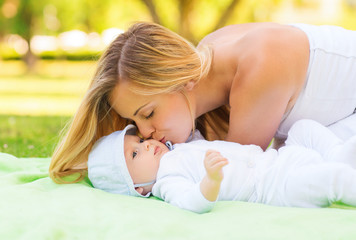 Obraz na płótnie Canvas happy mother lying with little baby on blanket
