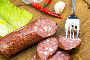 sausages on a wooden plate with vegetables in a restaurant