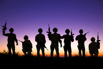 Fototapeta na wymiar silhouette of Soldiers team with sunrise background