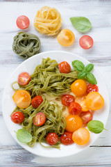 Boiled colored tagliatelle and roasted tomatoes, view from above