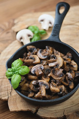 Frying pan with roasted champignons, vertical shot, close-up