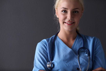 Young doctor woman with stethoscope isolated on grey background