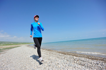 Runner athlete running on stone beach of qinghai lake