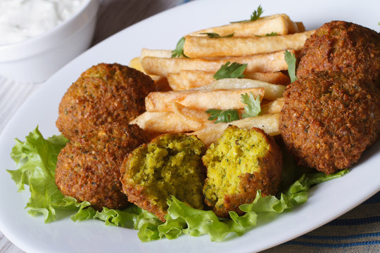 falafel with French fries on a white plate and tzatziki