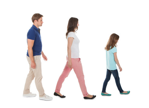 Family Walking In A Row Over White Background