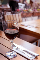 one glass of red wine on a table at cafe