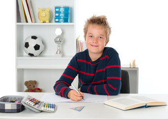 smiling boy is doing homework