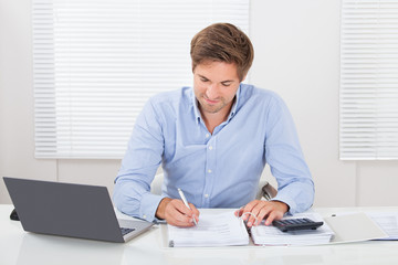 Businessman Working At Desk In Office