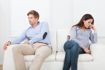 Couple Ignoring Each Other On Sofa