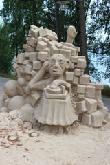 Eine Sandskulptur zeigt einen Mann beim Mittagessen