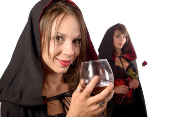 two young women in disguise halloween with a glass of blood and
