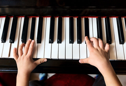 Child's hands playing the piano