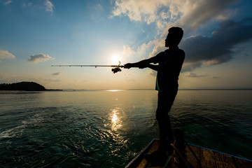 siluette of unidentified man fishing with rod