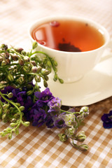 Cup of fresh herbal tea on table