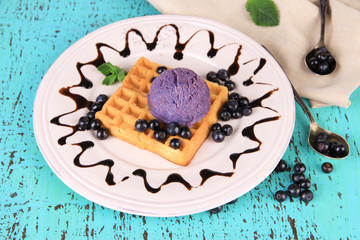 Tasty belgian waffles with ice cream on wooden table