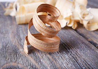 Wood shavings on grey wooden background closeup