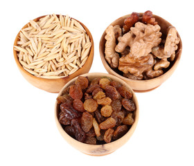 Small wooden bowls with raisins, walnuts and oats isolated