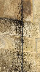 Teerspritzer an Sandsteinwand