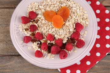 Big pink plate with oatmeal and berries on a polka dot napkin
