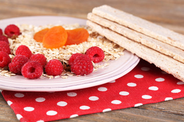 Big plate with oatmeal, small loaves of bread and berries