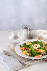 Green salad with apples, walnuts and cheese on light background