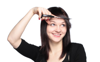 Obraz premium Young woman cutting her fringe over white background