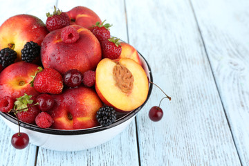 Peaches and berries in bowl on table