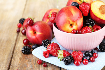 Peaches and berries in bowl on table close-up